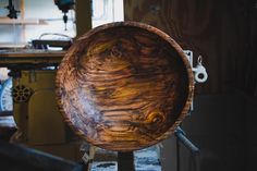 a large wooden bowl sitting on top of a table next to a pair of scissors