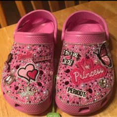 a pair of pink children's shoes with hearts and princess patches on the side