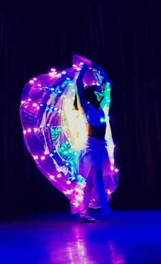 a woman is dancing with lights on her body