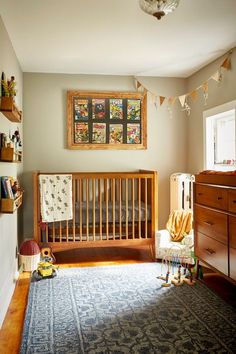 a baby's room with a crib, dresser and bed in it that has an area rug on the floor