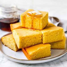 a stack of cornbreads on a plate with honey drizzled over them