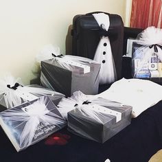 several bags and packages are sitting on a bed next to a framed photo, some with white tulle