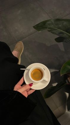 a woman holding a cup of coffee in her hand