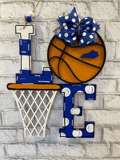 a basketball and hoop hanging on the side of a brick wall with polka dot bows