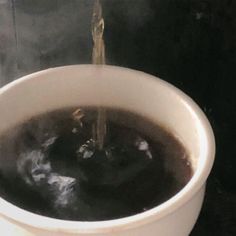 a white bowl filled with liquid on top of a stove