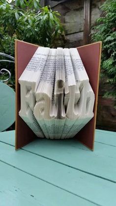 an origami book with the word love folded in it