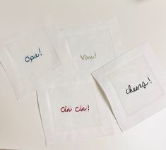 four embroidered napkins with the words vive, vie, cher and chevre on them