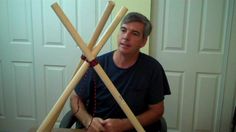 a man sitting in front of two wooden sticks