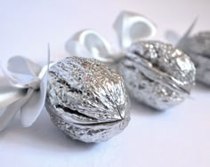 three pieces of silver foil wrapped in white ribbon