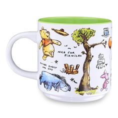 a winnie the pooh mug with many different things on it's front and side