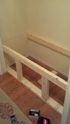 a wooden bench sitting on top of a hard wood floor next to a door way