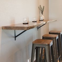 three bar stools sit at the edge of a counter