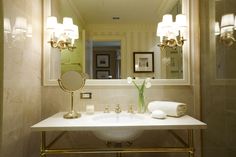 an image of a bathroom with pictures on the wall and in front of the sink