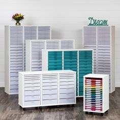 three white storage cabinets with drawers and dividers on each side in front of a sign that says dream