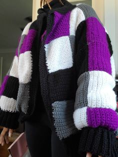 a woman wearing a black, white and purple sweater