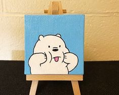 a small easel with a painting of a white bear on it's side