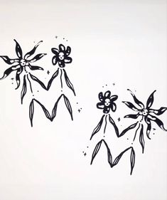 three black and white flowers are drawn on a sheet of paper with stars in the background