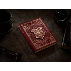 a hogwarts book sitting on top of a table next to a coffee cup