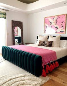 a bedroom with a bed, mirror and rug