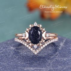 a blue diamond ring on top of a rock