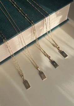 four necklaces are sitting on top of a book