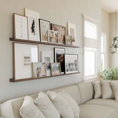 a living room filled with lots of furniture and pictures on the wall above it's couch