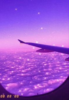 the view from an airplane window looking out at the clouds and stars in the sky