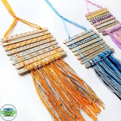 three necklaces with different colored tassels and beads hanging from the side on a white surface