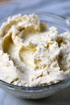 a glass bowl filled with cream cheese on top of a table