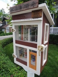 a little library in the middle of some grass