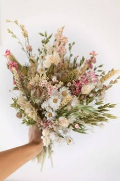 a person holding a bouquet of flowers in their hand