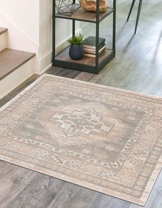 an area rug is placed on the floor in front of a book shelf and stairs