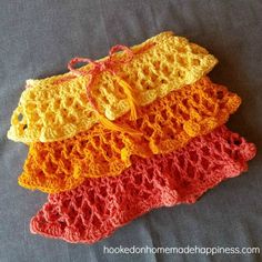 three crocheted purses are sitting on a bed together, one is yellow and the other is red