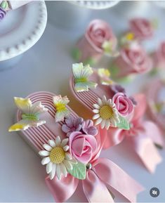 pink hair combs decorated with flowers and butterflies on top of a white tablecloth