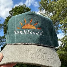 Vintage Style Sunkissed Embroidered Faded Canvas Snapback Trucker Rope Hat with Free Shipping. White and orange stitched text/logo. Condition is "New with tags". Shipped with USPS First Class. Step into the world of the great outdoors with our Sunkissed Stitched Green Faded Canvas Rope Hat. With its faded canvas and rope accents, this hat exudes rustic charm. Plus, enjoy free shipping on this vintage-inspired accessory that's perfect for any travel, vacation, or lake day. *Condition is "New with tags". Shipped with USPS First Class. *This is a medium profile hat that will fit most medium to large sized heads  *Please feel free to message us questions about the fit; we don't mind!  *Each listing includes 1 vintage style mesh back trucker hat with an embroidered design.    If this hat/design Casual Trucker Hat With Embroidered Logo For Outdoor, Casual Outdoor Trucker Hat With Embroidered Logo, Casual Orange Hat With Embroidered Logo, Casual Outdoor Snapback Hat With Embroidered Patch, Summer Dad Hat With Embroidered Logo And Flat Brim, Casual Snapback Hat With Embroidered Patch, Green Casual Snapback Hat With Embroidered Logo, Casual Orange Flat Brim Trucker Hat, Casual Orange Snapback Hat With Flat Brim