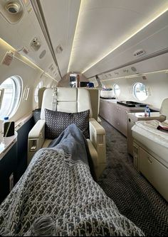 the inside of an airplane with two beds and couches on each side of it