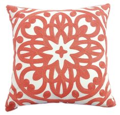 a red and white pillow with an intricate design on the front, sitting against a white background