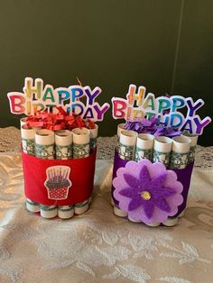 two jars filled with candles on top of a table covered in paper and decorations that say happy birthday