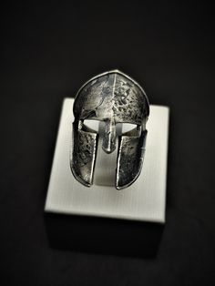 Spartan Helmet Silver Handmade Ring The Spartan helmet is one of the most iconic and popular symbols of ancient Greece. The efficient and simple design helped to protect most of the head while providing access to the senses of the warrior and struck fear into enemies. The Spartan symbol in classic art represents strength, loyalty, courage, and honor. Our ring design focuses on the Spartan helmet with a simple and elegant view. It helps you to remind how strong, courage and loyal a human can be. It can be of special motivation for ones acting in military, sports, or similar competitive areas. Our products are based on a special design and handmade of 925 sterling silver. It's suitable for everyday use but also can be preferred as a gift for your family, friends, and your loved ones as a lon Helmet Ring, Warrior Ring, Ring Man, Spartan Helmet, Ancient Greece, Personalized Products, Classic Art, Handmade Ring, Handmade Silver