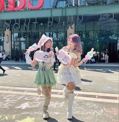 two young women dressed in costumes standing on the street