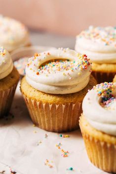 several cupcakes with white frosting and sprinkles