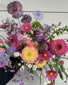 a vase filled with lots of different colored flowers