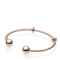 A sleek addition to your jewelry box, Pandora's 14K rose gold-plated Pandora Moments Open Bangle is minimally detailed with silicone stoppers that double as adornments. The polished style is plated with 14K rose gold for a warm finish. The logo-embossed end caps are easily removed to add charms — and are interchangeable to suit your mood. Classic Adjustable Rose Gold Bangle, Adjustable Modern Rose Gold Bangle, Modern Adjustable Rose Gold Bracelets, Pandora Logo, Pandora Rose Gold, Open Bangle Bracelet, Pandora Rose, Polished Style, Bracelet Pandora