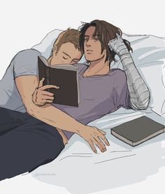 two people are laying in bed and one is reading a book while the other looks at an electronic device