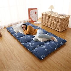 a woman is laying on an inflatable mattress with flowers and leaves printed on it