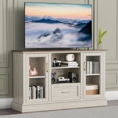 a flat screen tv sitting on top of a wooden entertainment center