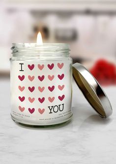 a candle with i love you stickers on it next to a canister lid