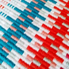 a close up view of the colorful knitted material on a blanket that is red, white and blue