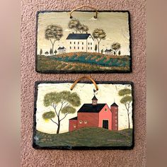 two paintings on the wall one has a barn and the other is a red house