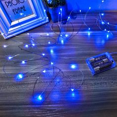 there are some blue lights on the floor next to an old photo frame and batteries